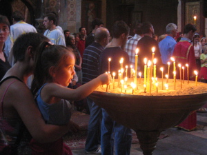 Tiko lights a candle in the church
